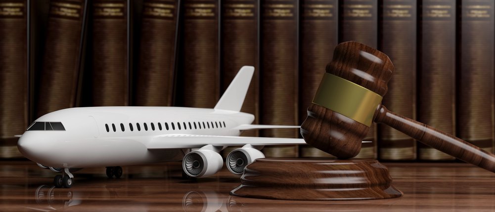 What is International Corporate Law Image of a blank commercial airplane next to a judge's gavel resting on legal books, featuring 411 Corporate Law and highlighting the complexities of international corporate law, ensuring it aligns with the page's context on aviation law and corporate regulations.